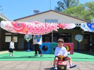 中庭で泳ぐこいのぼりと一緒に遊んだりの様子